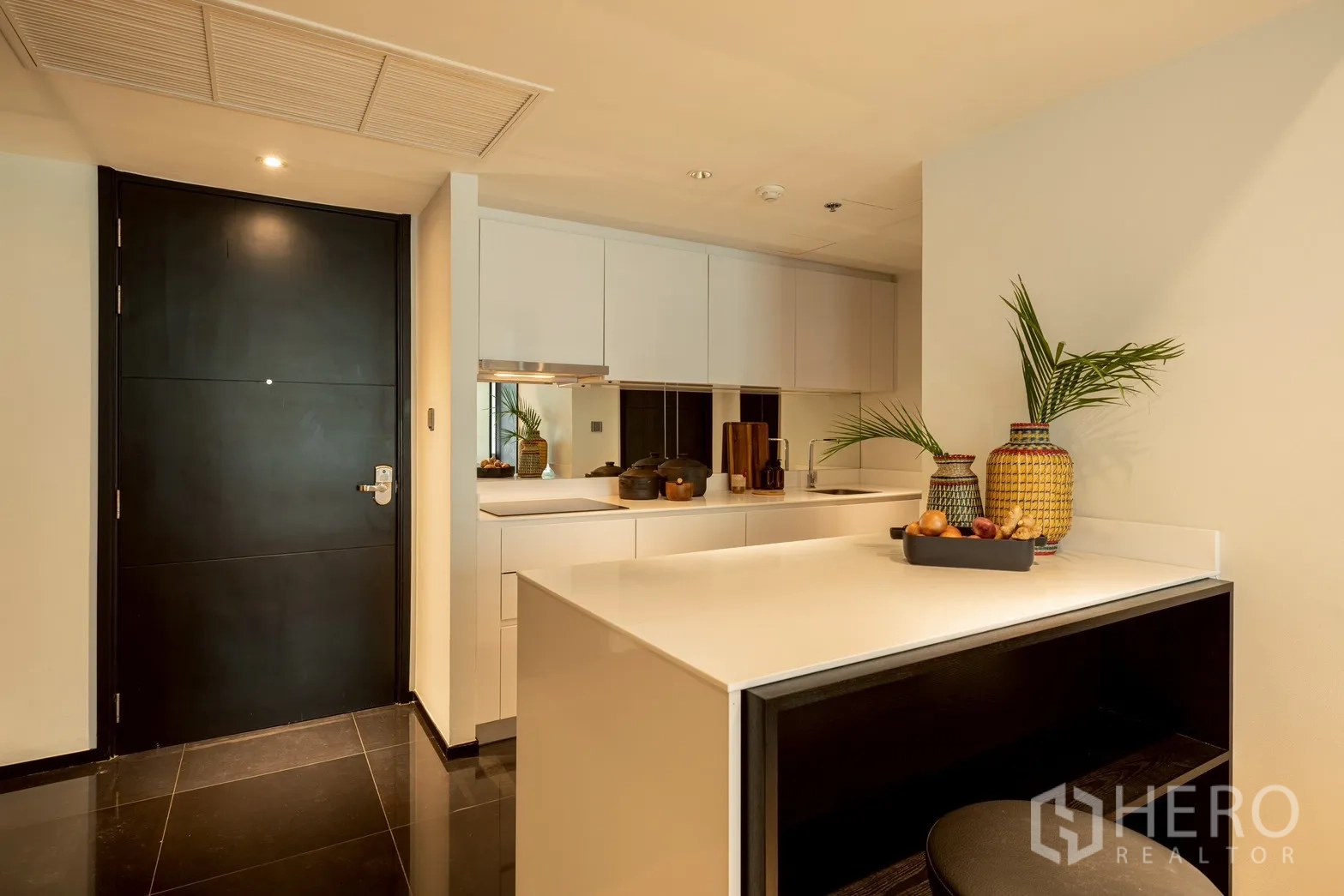 公寓 for rent or sale in Pathum Wan, Bangkok - 现代白色厨房，吧台、吊柜与镜面防溅板。