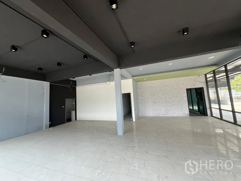 零售空间 出租在Saphan Sung, Bangkok - 明亮的室内零售空间，瓷砖地面，外露灯轨与玻璃门。