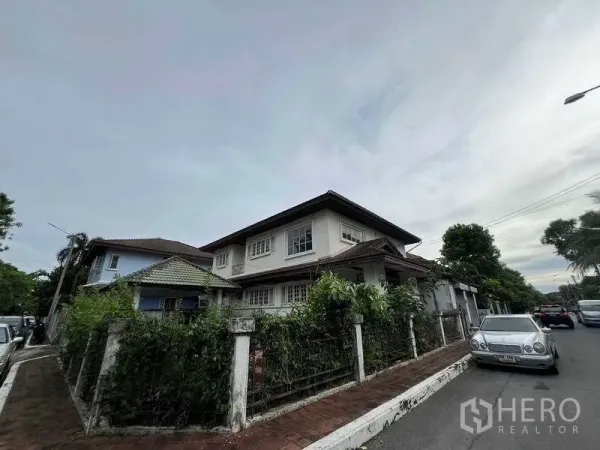 บ้าน ขายในPhra Khanong, Bangkok - มุมมองหัวมุมของที่ดิน พร้อมรั้วปกคลุมด้วยไม้เลื้อย และทางเท้ากว้างบนถนนที่อยู่อาศัยเงียบสงบ