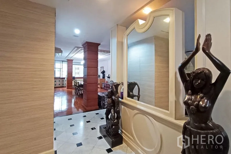 公寓 出售在Bangkok - 雅致走廊，米色大理石地面、墙面镜与装饰雕塑。