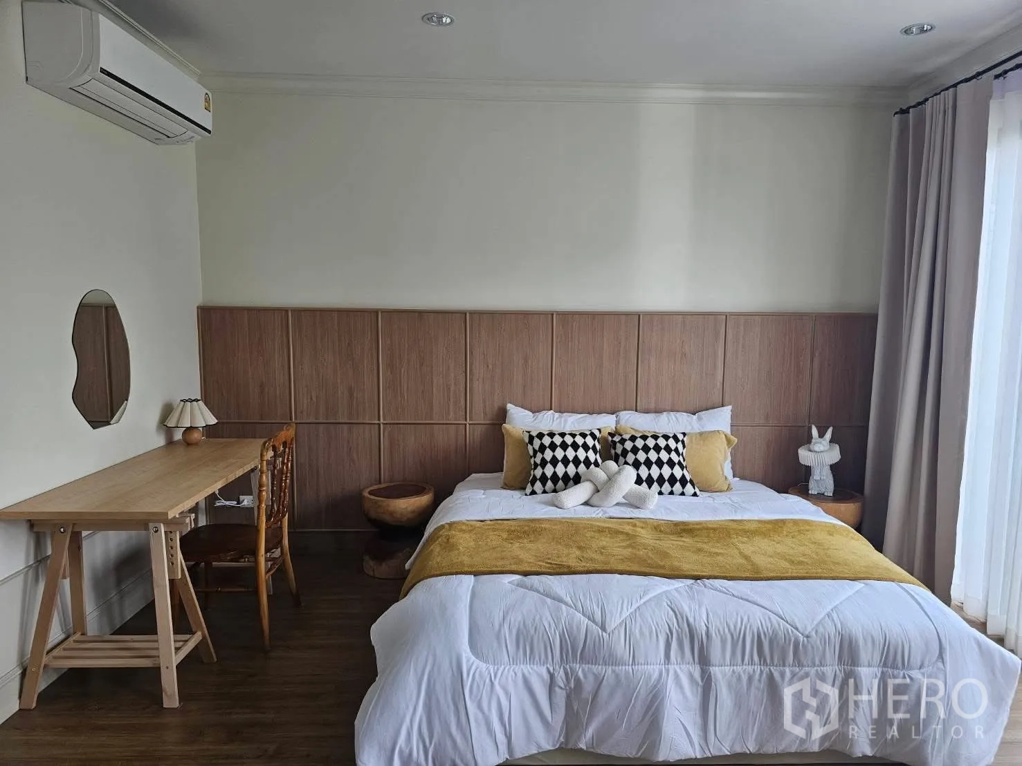 ทาวน์เฮาส์ for rent in Saphan Sung, Bangkok - ห้องนอนหลัก ผนังหัวเตียงไม้ โต๊ะทำงาน เครื่องปรับอากาศ และหน้าต่างบานใหญ่พร้อมผ้าม่าน