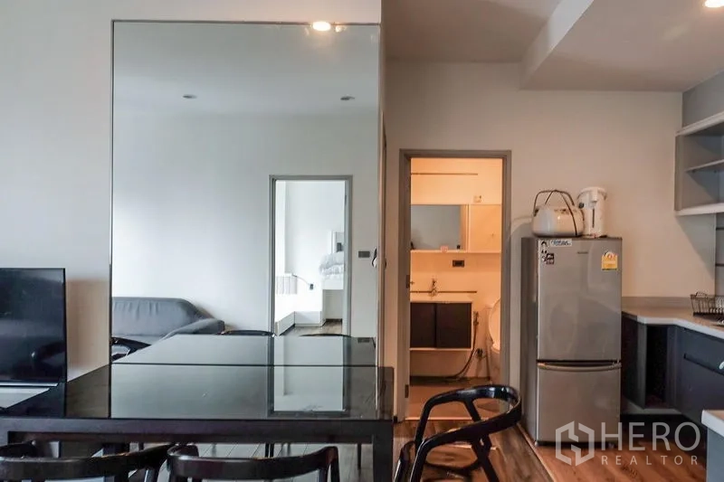 公寓 出租在Khlong Toei, Bangkok - 客厅另一角度，沙发、高窗及城市景观。