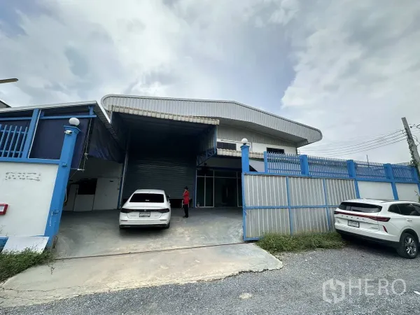 工厂 出租或出售在Bang Yai, Nonthaburi - 工厂正门外观，蓝色围栏、装卸雨棚与卷帘门。