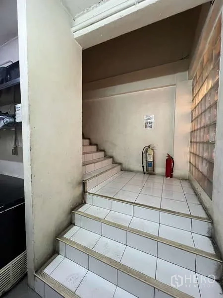 店屋 出租或出售在Khlong Toei, Bangkok - 室内瓷砖楼梯，平台处配有灭火器