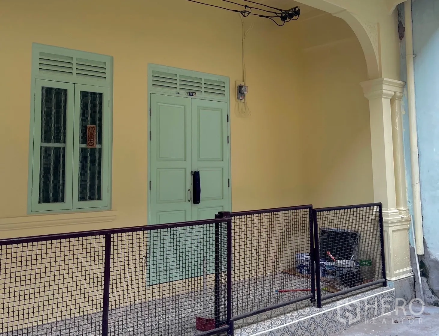 Shophouse for rent in Bang Rak, Bangkok - Shophouse entrance with mint doors, windows, and small gated patio.
