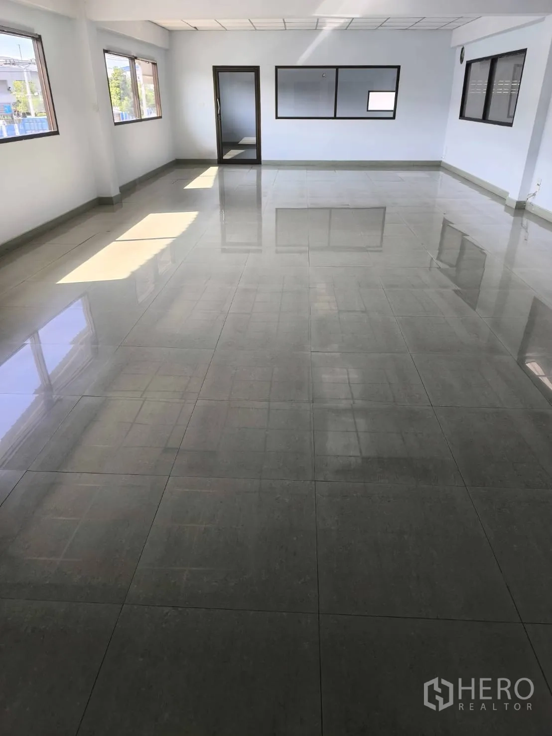 Factory for sale in Khlong Luang, Pathum Thani - Spacious upper-floor office with multiple windows and a glass door.
