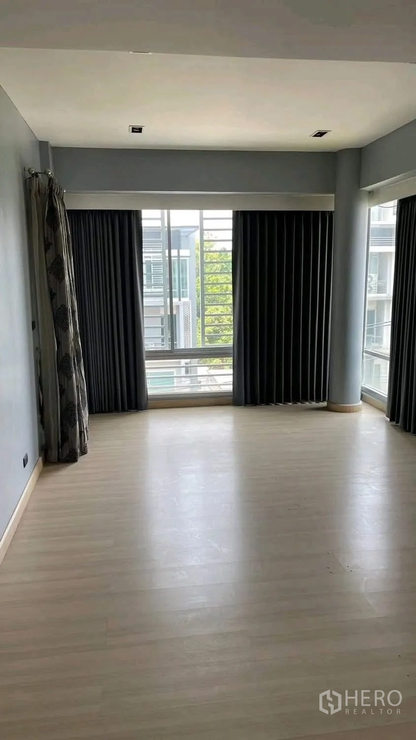 家庭办公室 for rent or sale in Wang Thonglang, Bangkok - 空置房间，浅木地板、窗帘与转角窗。