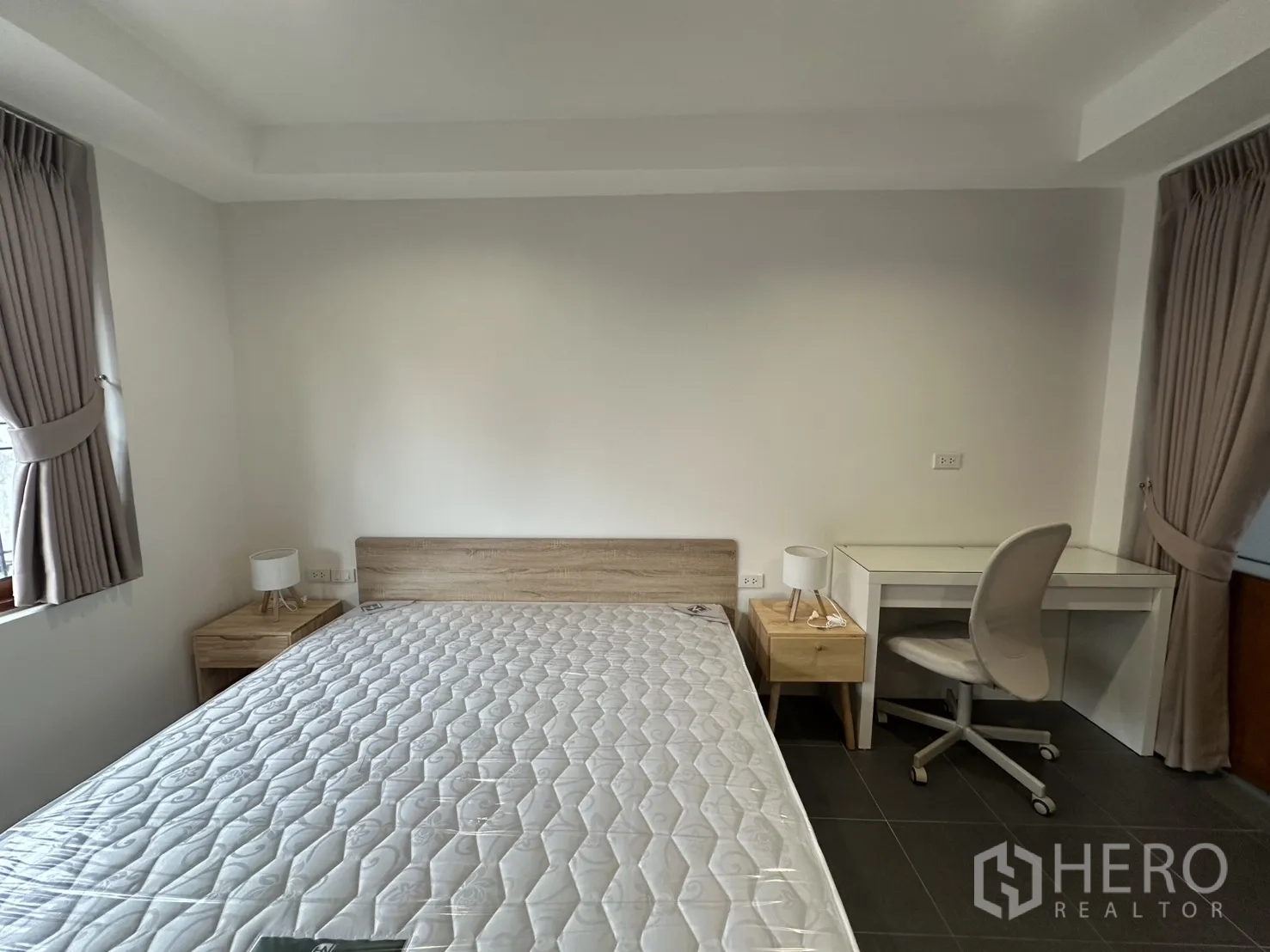 Apartment for rent in Pathum Wan, Bangkok - Large studio-style bedroom with TV unit, bed, indoor plant, and ample floor space.