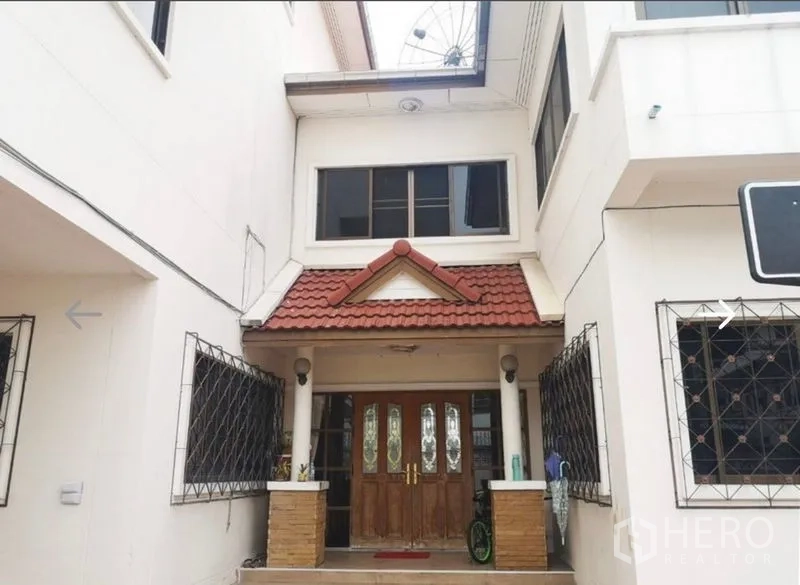 Detached House for sale in Khlong San, Bangkok - Covered front porch featuring a red-tile gable roof and double wooden entrance doors.