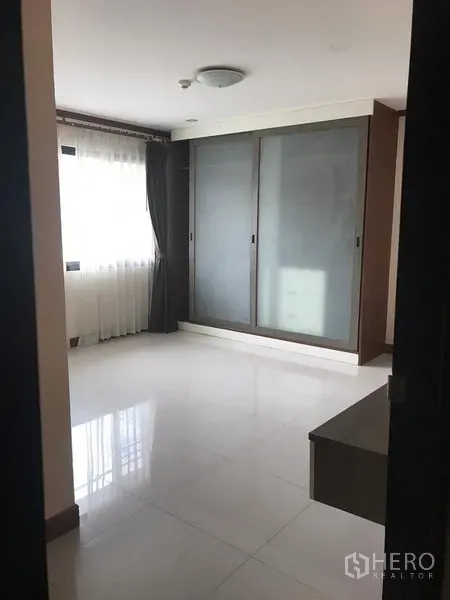 อพาร์ทเมนท์ ให้เช่าในWatthana, Bangkok - ห้องนอนพร้อมตู้เสื้อผ้าบานเลื่อนกระจกฝ้าและหน้าต่างผ้าม่านโปร่ง