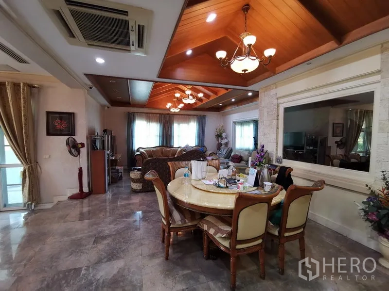 独立式住宅 出售在Phra Khanong, Bangkok - 餐厅与家庭厅一体，石材地面，木质格栅天花与吊灯。