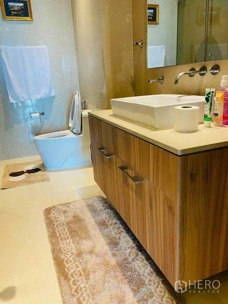 Condominium for rent in Watthana, Bangkok - Master bedroom with floral bedding, built-in wardrobe with TV niche, and balcony access.