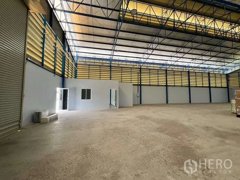 Warehouse for rent in Lat Lum Kaeo, Pathum Thani - Open-plan warehouse interior showing roller shutter and small office rooms.