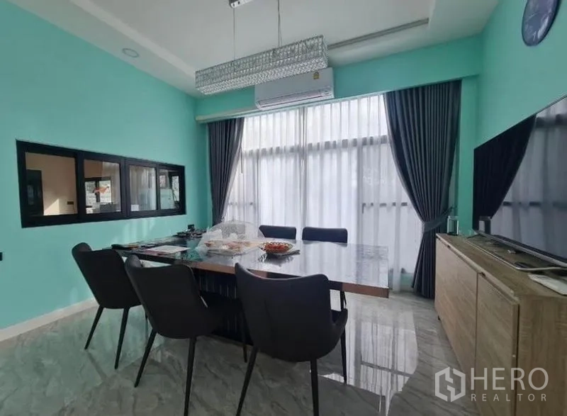 บ้าน ขายในSai Mai, Bangkok - ห้องรับประทานอาหารมุมอื่น โต๊ะยาว ผนังสีเขียวมิ้นต์ และผ้าม่านทึบ