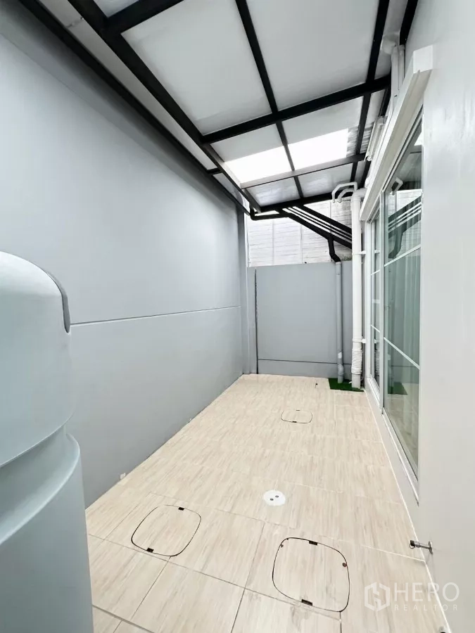 联排别墅 出租在Prawet, Bangkok - 覆顶生活阳台，瓷砖地面与推拉玻璃门。