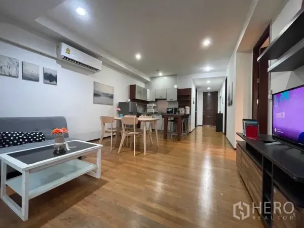 Condominium for rent in Din Daeng, Bangkok - Open-plan living, dining and kitchenette with wood floors and recessed lighting.