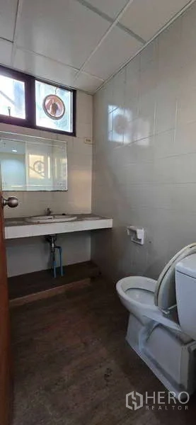 办公空间 出租 - 简洁卫生间，坐便器、洗手台与镜子，带采光窗。