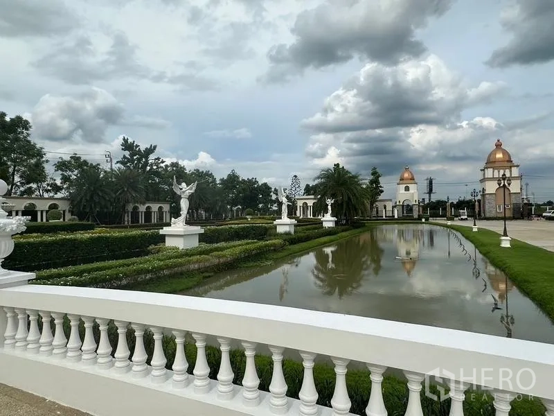 Detached House for sale in Bang Khen, Bangkok - Landscaped community garden featuring a canal, statues, and domed gatehouses.