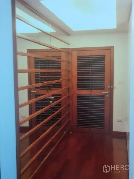 คอนโด ให้เช่าในWatthana, Bangkok - พื้นที่โถงทางเข้ามีบานประตูลูกฟักระแนงไม้ ผนังกั้นไม้ซี่ และไฟเพดานโทนอุ่น