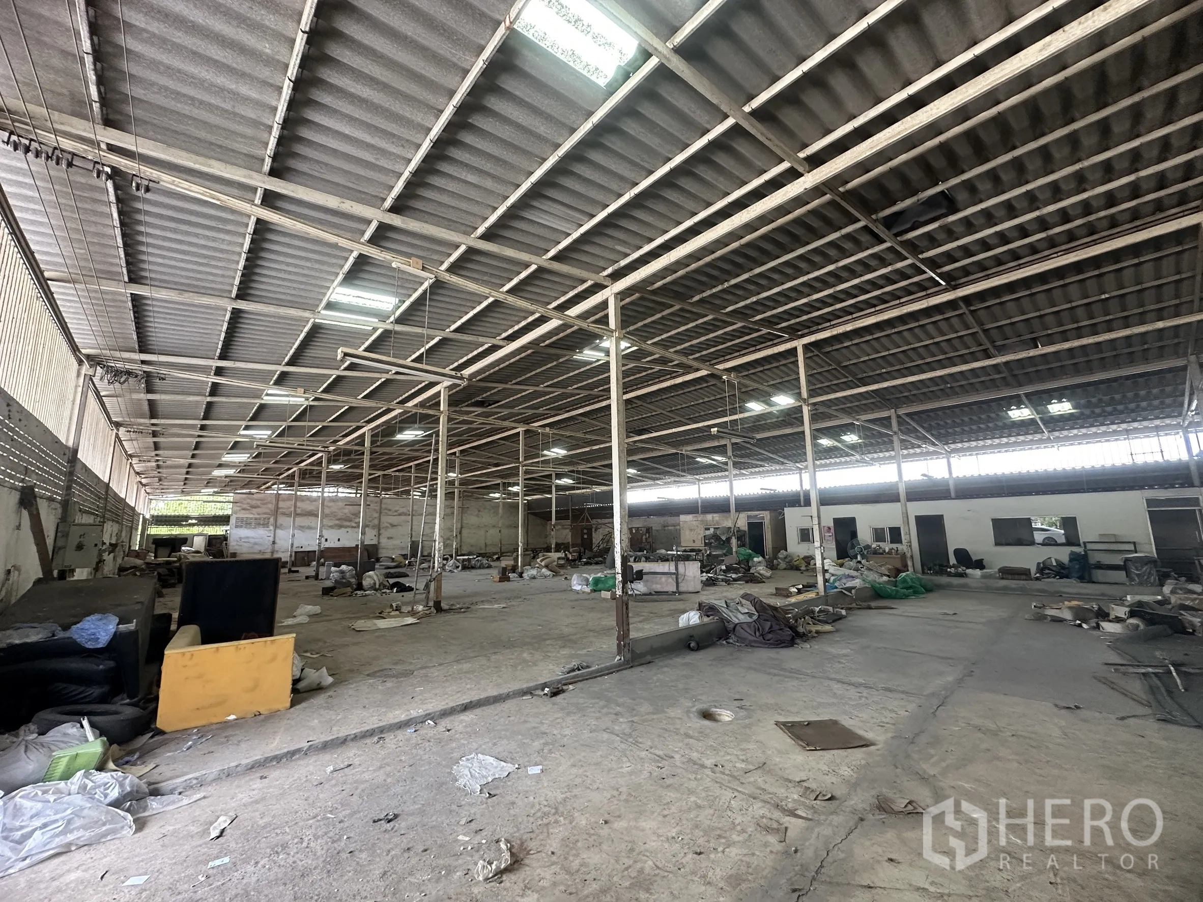 Warehouse for rent in Lam Luk Ka, Pathum Thani - Interior bay with high roof, columns and service rooms on the right.