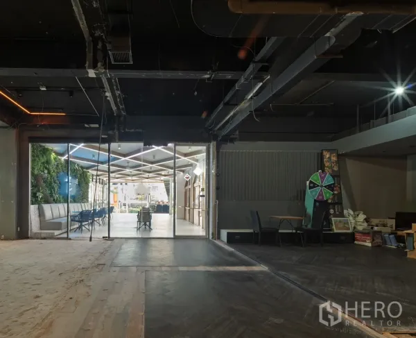 零售空间 出租在Watthana, Bangkok - 原始状态的零售室内，玻璃门面连通明亮中庭与立体绿植区。