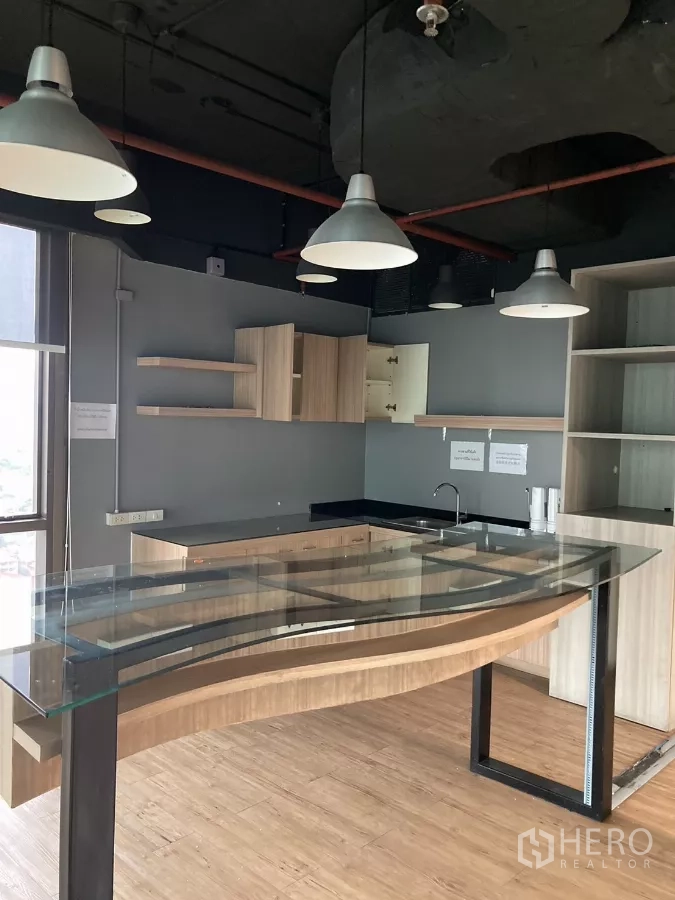 Office Space for rent in Watthana, Bangkok - Pantry with cabinets, sink and curved glass-topped counter in a Watthana workspace.