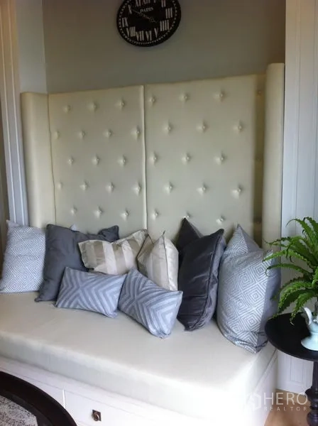 คอนโด ให้เช่าในBangkok - ที่นั่งติดหน้าต่างพนักพิงบุผ้า หมอนหลายใบและโต๊ะข้าง