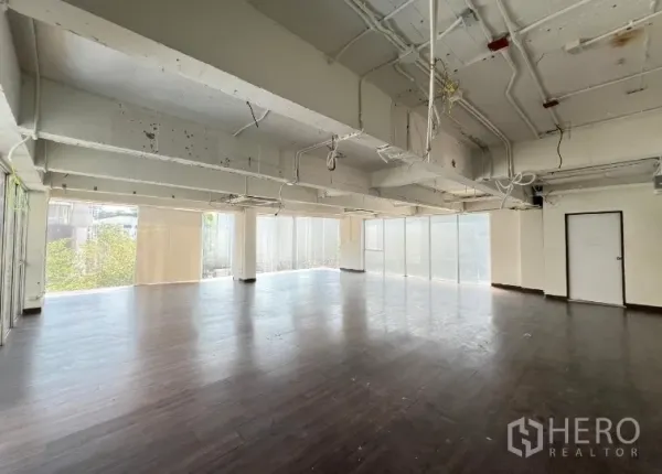 零售空间 出租在Watthana, Bangkok - 开放式零售室内，深色木地板、外露天花与落地窗采光充足。