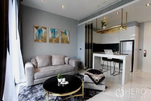 Condominium for rent in Bangkok - Bright living space with sofa set, round coffee table and island kitchen.