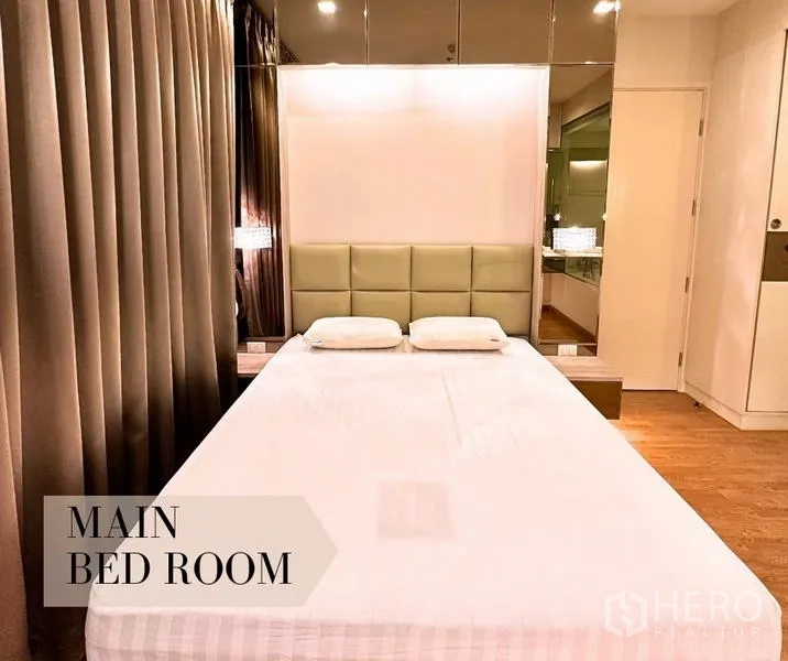 คอนโด ให้เช่าในWatthana, Bangkok - ห้องนอนหลักหัวเตียงบุ ผนังกระจกเงา และแสงไฟนุ่มนวล