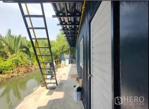 โรงงาน for rent or sale in Mueang Samut Sakhon, Samut Sakhon - ทางเดินริมคลองข้างอาคารบริการสีดำขาวพร้อมบันไดภายนอก