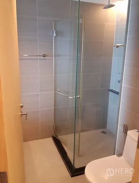 公寓 出租在Khlong Toei, Bangkok - 第二卫浴，玻璃步入式淋浴间与坐便，灰色瓷砖。