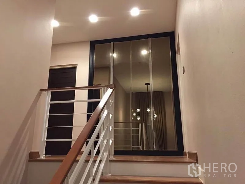 บ้าน ให้เช่าหรือขายในKhlong Toei, Bangkok - โถงบันไดราวสีขาว พร้อมบานเลื่อนกระจกเงาเต็มสูงและไฟสวยอบอุ่น