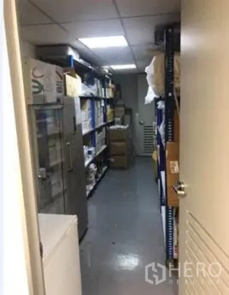 办公空间 出租在Khlong Toei, Bangkok - 狭长储藏室，金属层架与纸箱在明亮灯光下排列。