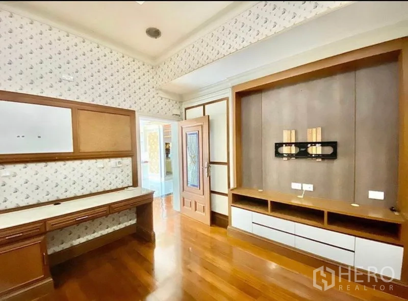 Home Office for rent in Pak Kret, Nonthaburi - Work or study room featuring a built-in desk, media wall and patterned wallpaper.