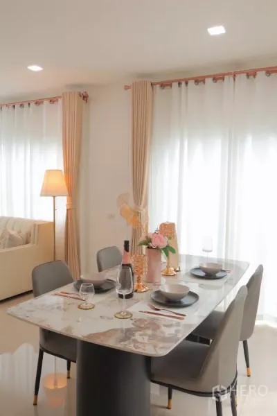 Detached House for rent in Bang Phli, Samut Prakan - Marble dining table set for four beside large curtained windows.