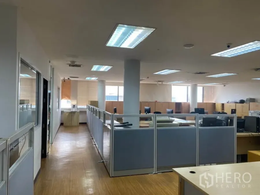 Office Space for rent in Lak Si, Bangkok - Open-plan office floor with cubicles, wood flooring, bright ceiling lights and wide windows.