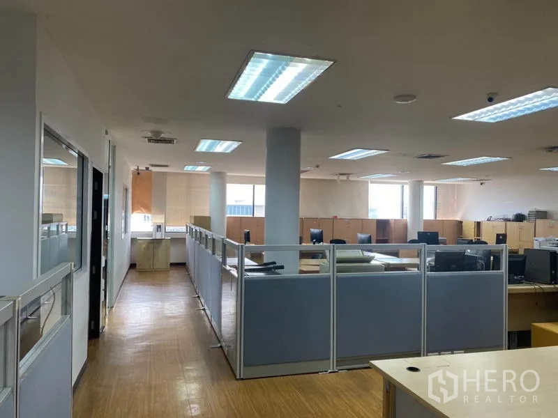 Office Space for rent in Lak Si, Bangkok - Open-plan office floor with cubicles, wood flooring, bright ceiling lights and wide windows.