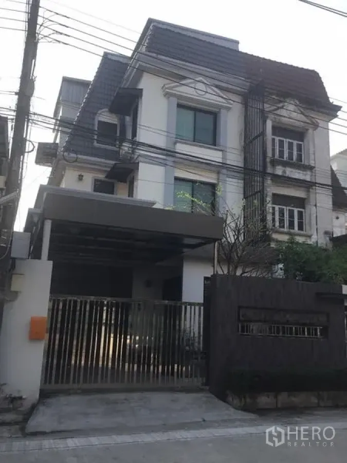 带办公室的家 出租在Suan Luang, Bangkok - 多层现代风格住办一体楼外观，带大门与有顶停车位。