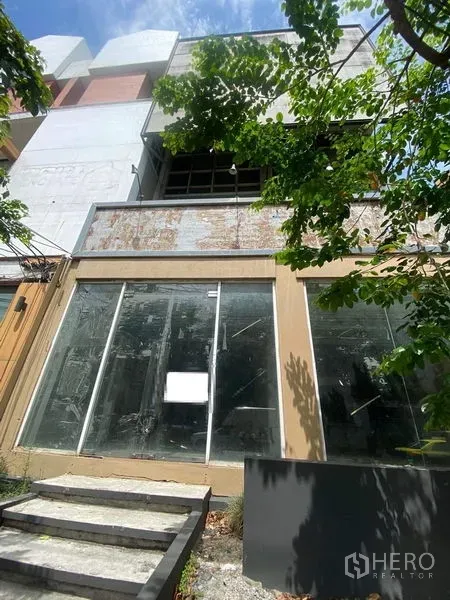 店屋 出售在Watthana, Bangkok - 曼谷艾卡迈街边多层店屋，临街落地玻璃门面与台阶入口，树荫遮蔽。