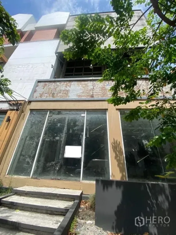 店屋 出售在Watthana, Bangkok - 曼谷艾卡迈街边多层店屋，临街落地玻璃门面与台阶入口，树荫遮蔽。