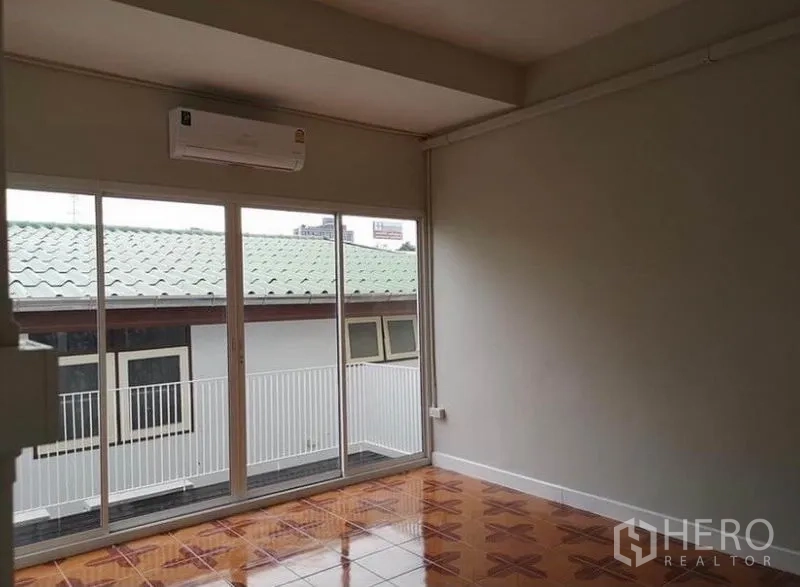 联排别墅 出租或出售在Din Daeng, Bangkok - 楼上卧室，整面玻璃门通阳台，图案瓷砖地面。