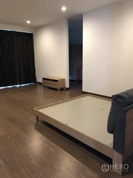 独立式住宅 出租在Prawet, Bangkok - 宽敞主卧，木地板、床架、筒灯与遮光窗帘。