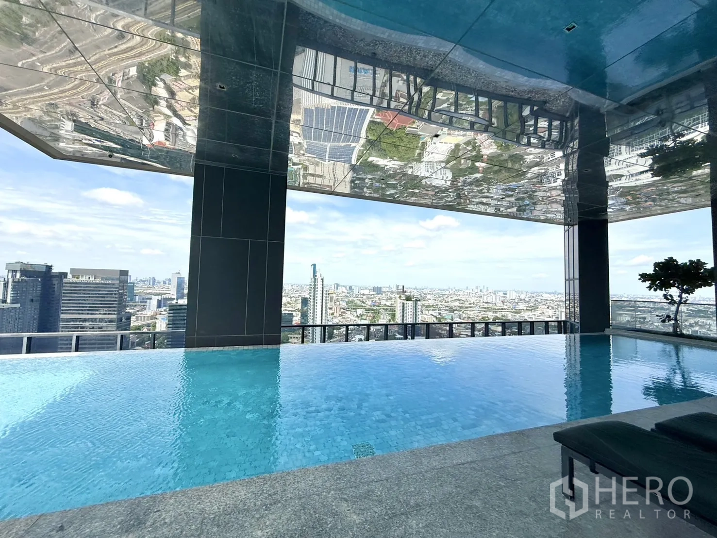 Condominium for sale in Chatuchak, Bangkok - Covered sky pool with panoramic city views and loungers.