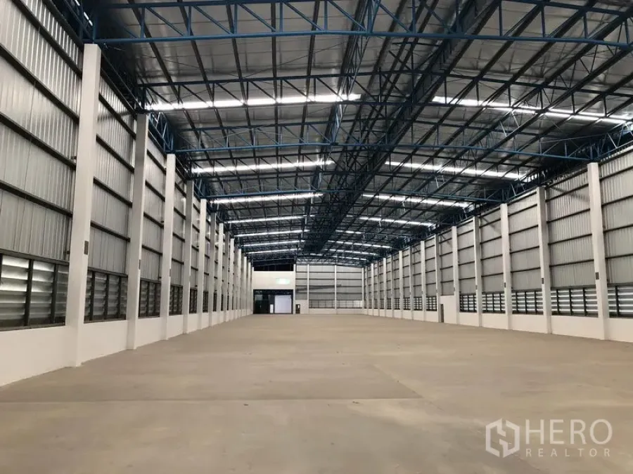 Warehouse for rent in Lat Krabang, Bangkok - Large warehouse interior in Lat Krabang, Bangkok with high steel truss roof, skylights and open concrete floor.