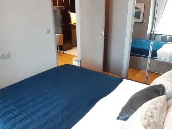 公寓 出租在Khlong Toei, Bangkok - 温馨卧室，镜面衣柜，门通向客厅。