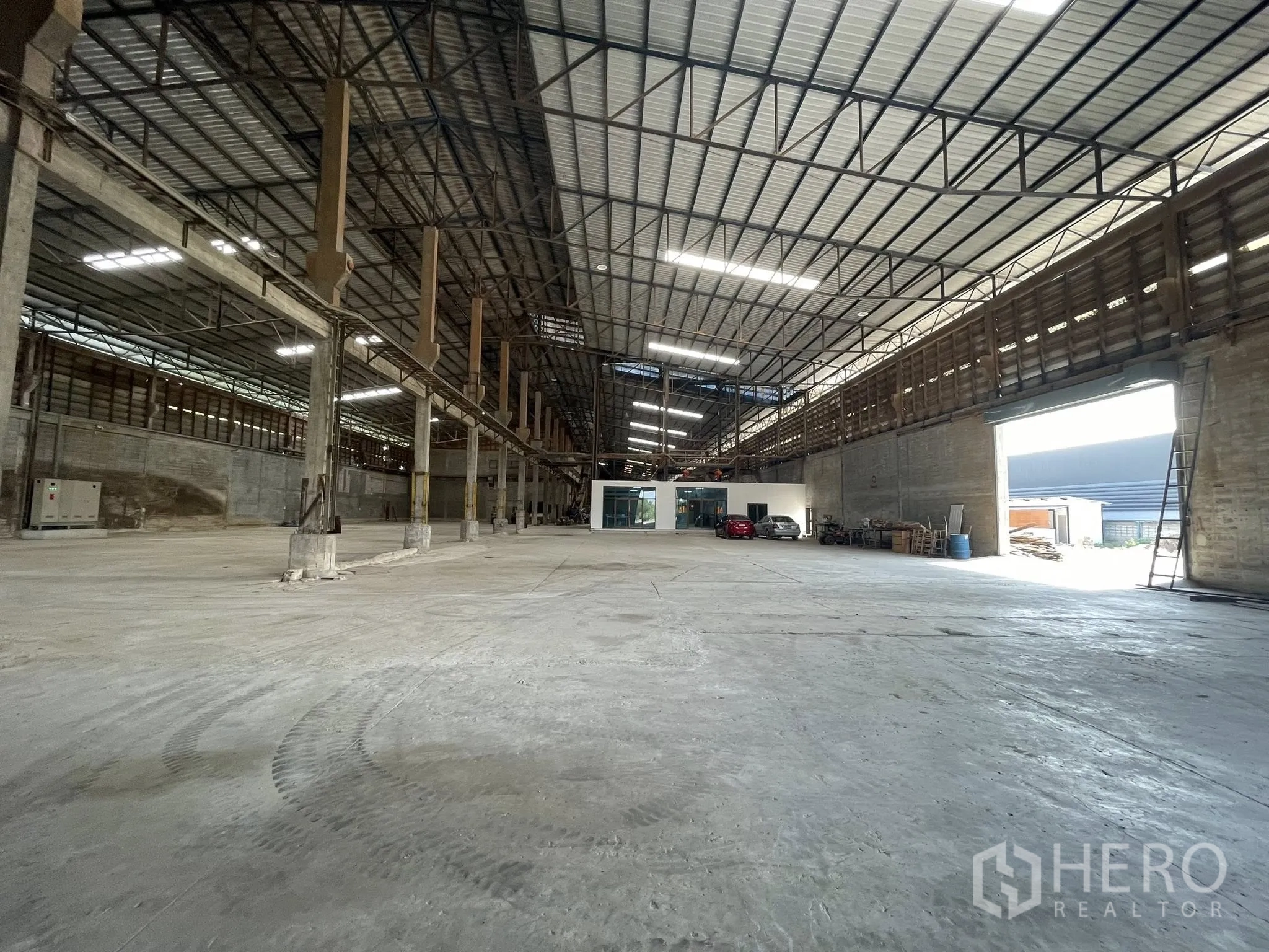 Factory for rent in Bang Bua Thong, Nonthaburi - Deep factory floor with high ceilings, natural light, and an internal office block and parking area.