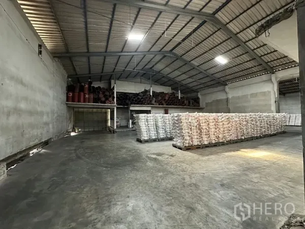 Warehouse for rent in Lat Krabang, Bangkok - Wide high-clearance warehouse space with palletized goods and ventilation panels.