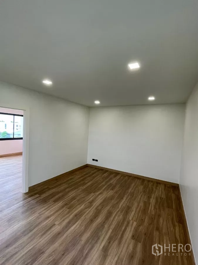 Home Office for rent in Khan Na Yao, Bangkok - Bright empty bedroom with wood flooring and recessed LED lights.