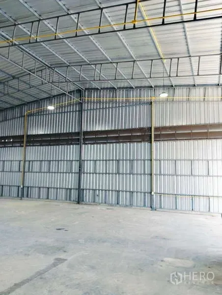 คลังสินค้า ให้เช่าในKhlong Sam Wa, Bangkok - ผนังเหล็กและพื้นที่โล่งของโกดัง เห็นท่อสาธารณูปโภคและโครงสร้างชัดเจน